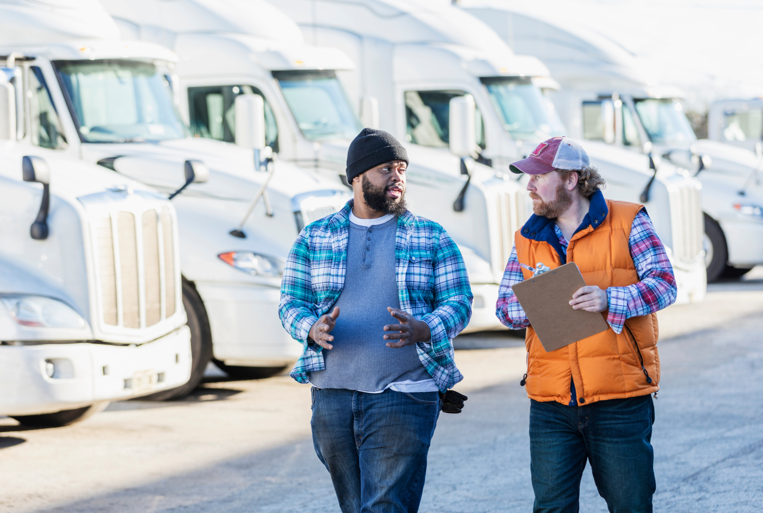 two truck drivers with trucks in the background talking about trucking authority