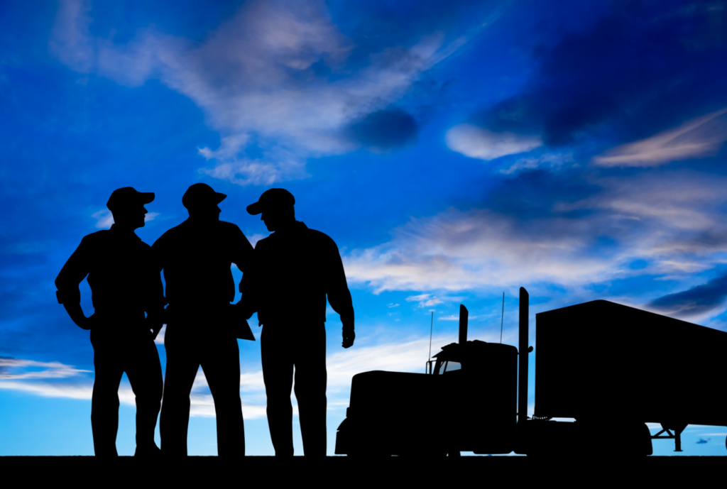 silhouette of three truck drivers and a truck