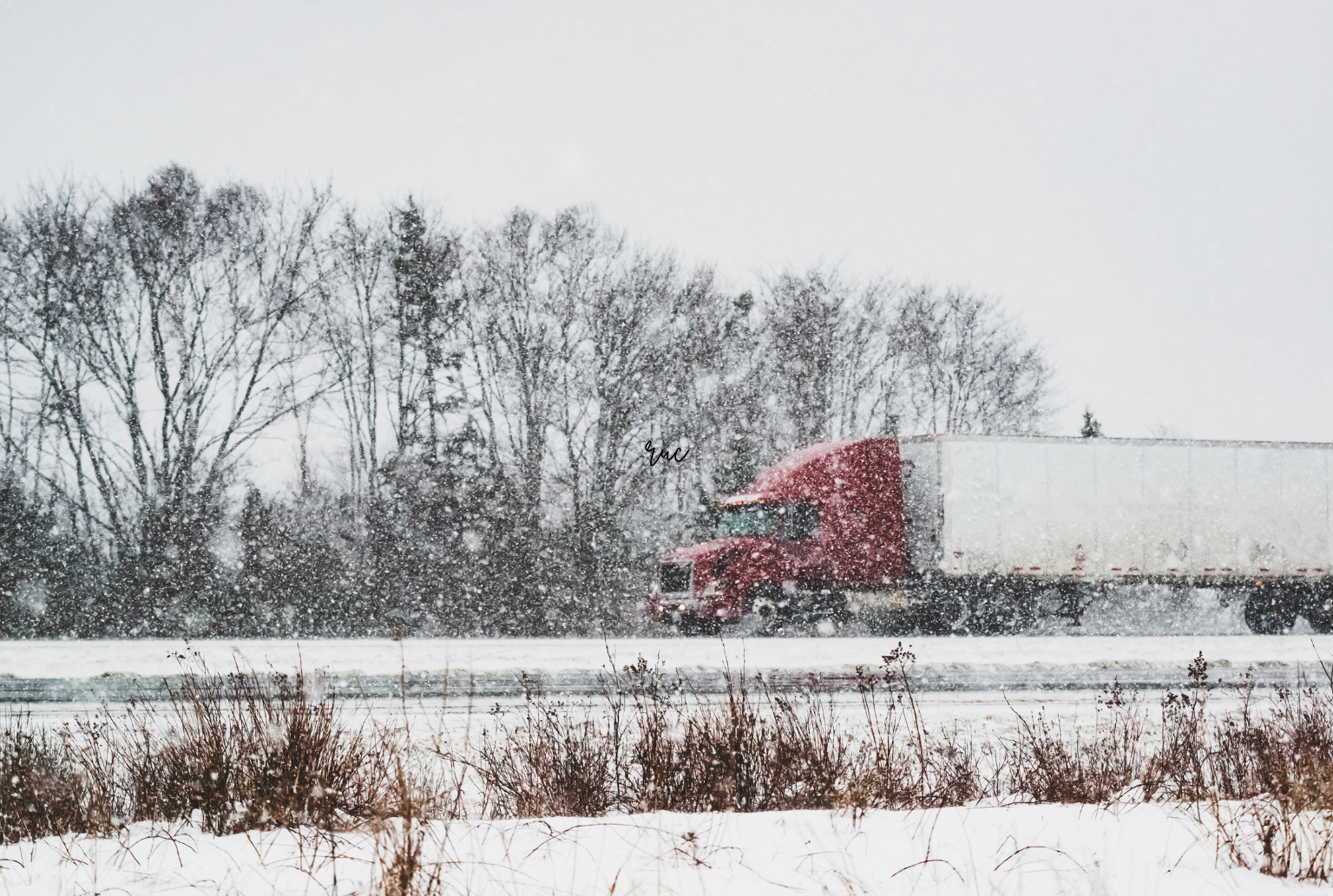 red truck driving on a winter road