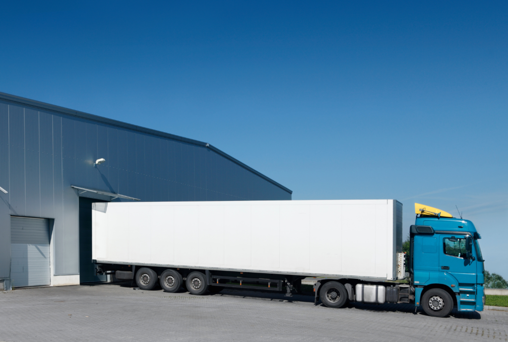 blue truck going out of warehouse trucking company