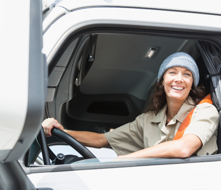 female truck driver wearing safety hat in truck
