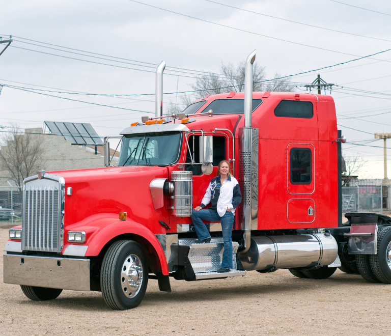 woman truck driver posing in red semi truck
