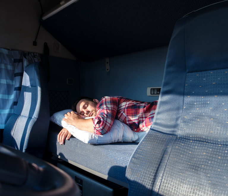 male trucker sleeping in truck cabin