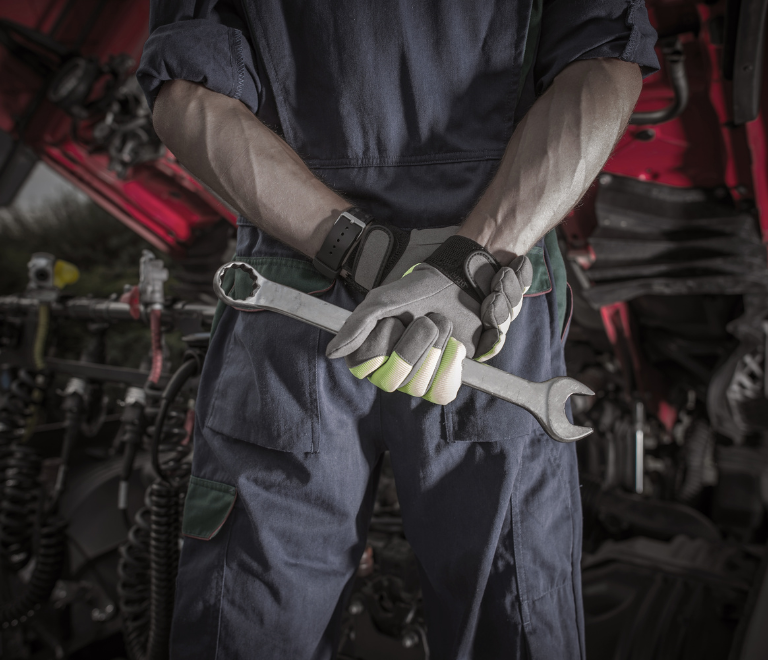 truck driver holding wrench for repair and maintenance